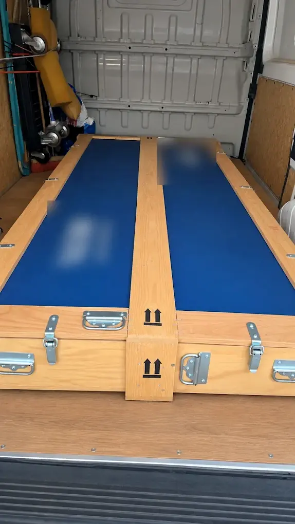 Table professionnelle dans sa caisse de transport en bois, calée à plat dans un utilitaire Proxi Paris entre Le Pré-Saint-Gervais et Saint-Denis